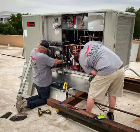 1 Call Heat & Air technicians installing a rooftop commercial AC unit