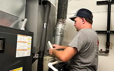 A technician from 1 Call Heat & Air performs maintenance on a customer's HVAC